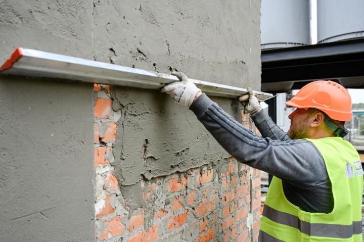 Нанесення штукатурного розчину на цегляну стіну